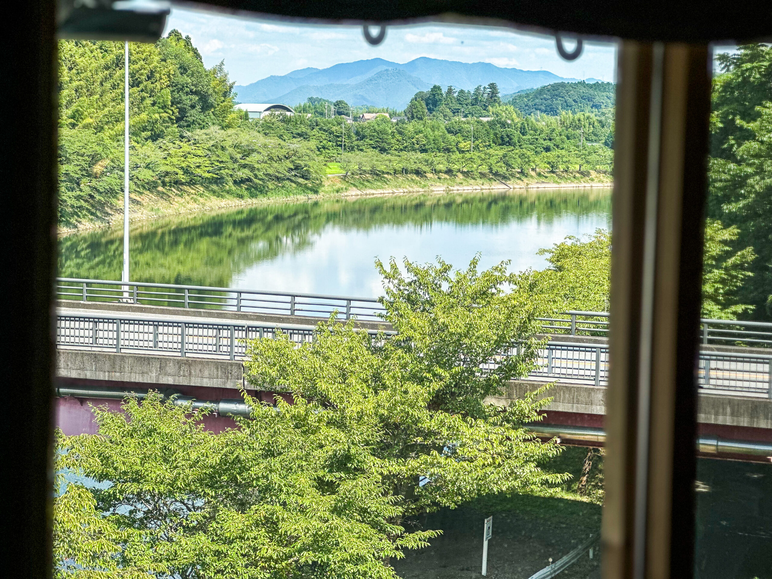 HAKURA 客室の窓から見える池と里山